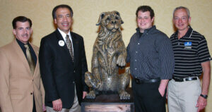 Dr. Somerville stands beside his son and others around the dog statue which now lives in Lynn Hall