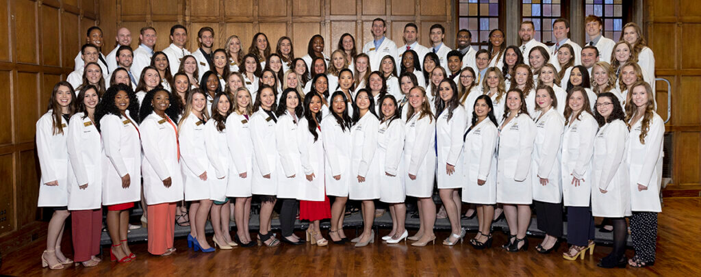 DVM students don their new white coats for a group photo at the ceremony