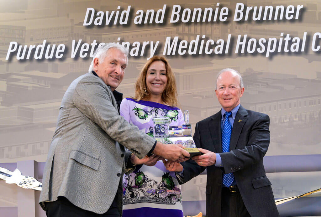 President Daniels presents Dr. David and Bonnie Brunner with the President's Council Crystal Train Award on stage