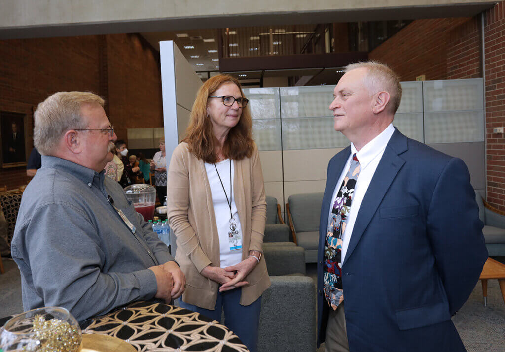 Dr. Baird in conversation with Dr. Weil and Pat in the Veterinary Medicine Library