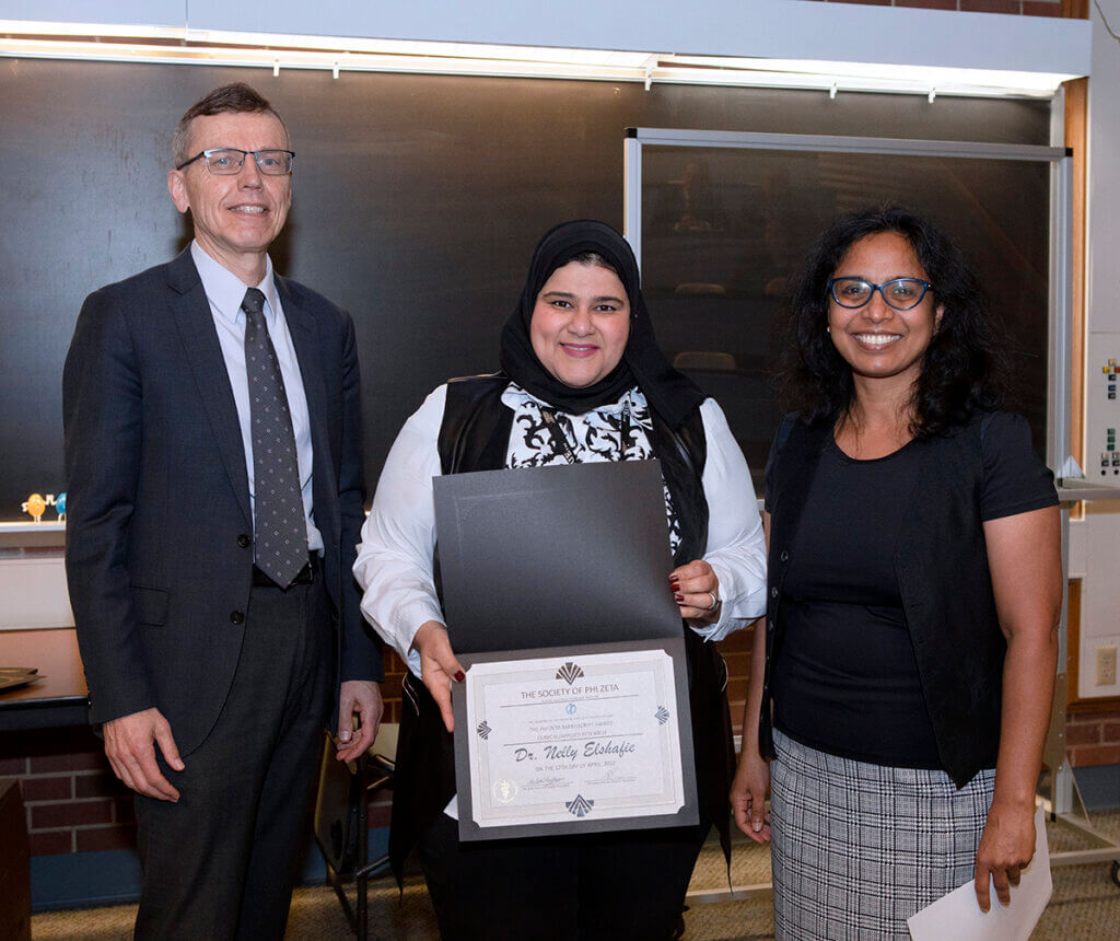 Dr. HogenEsch and Dr. Raghavan stand beside Dr. Elshafie as she holds up her certificate