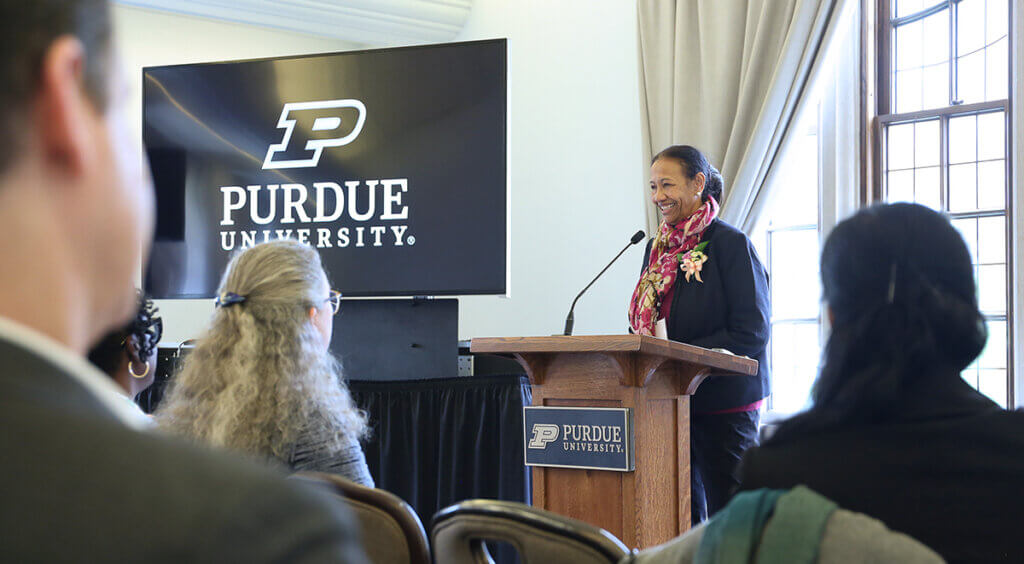 Sulma smiles as she speaks from a podium in front of the event guests