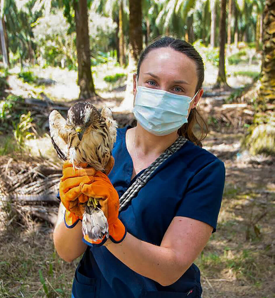 Bre is shown holding Bartolome as she stands in a grassy opening surrounded by trees