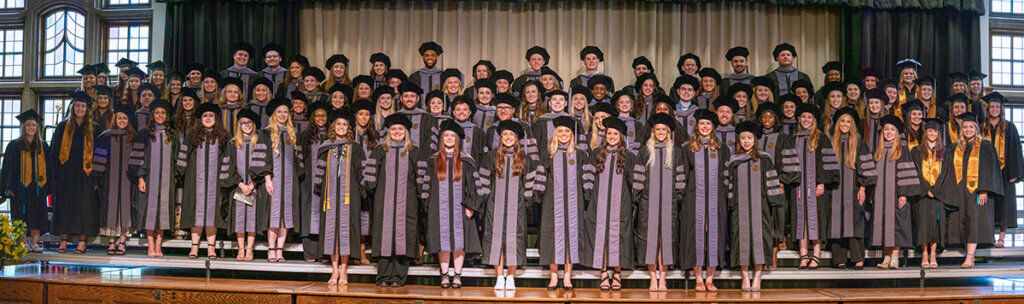 DVM and Veterinary Nursing graduates join together on the stage for a group photo