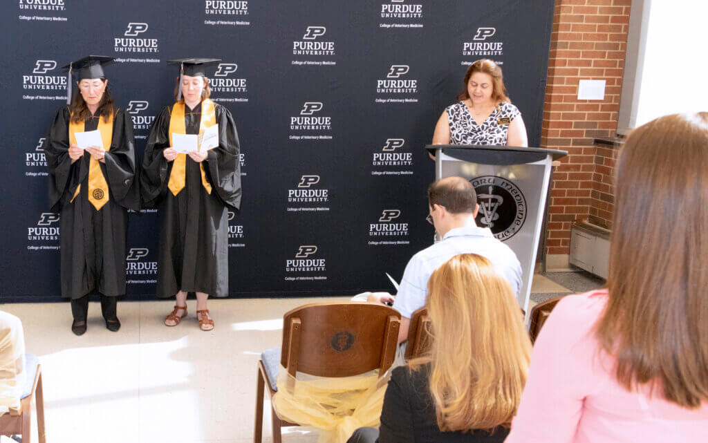 Brenda and Jennifer recite the oath in front of the audience as Jennifer leads them from the podium