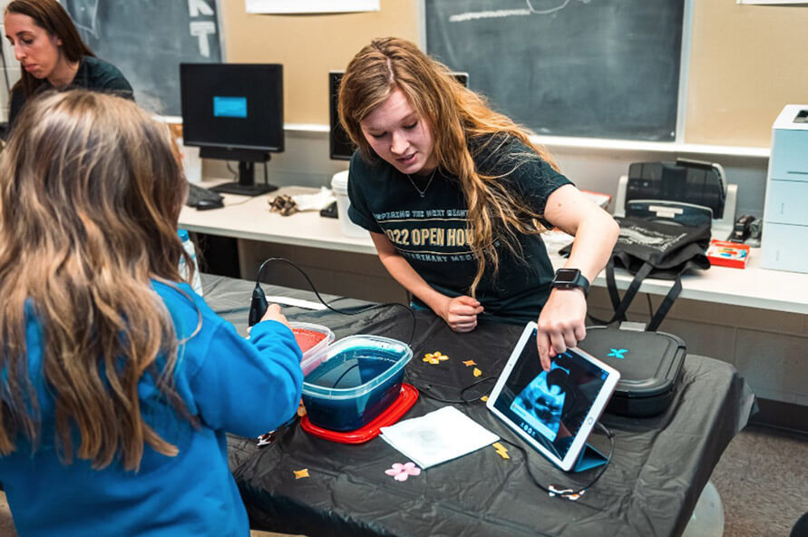 veterinary student demonstrates the handheld Butterfly iQ+ Vet ultrasound unit