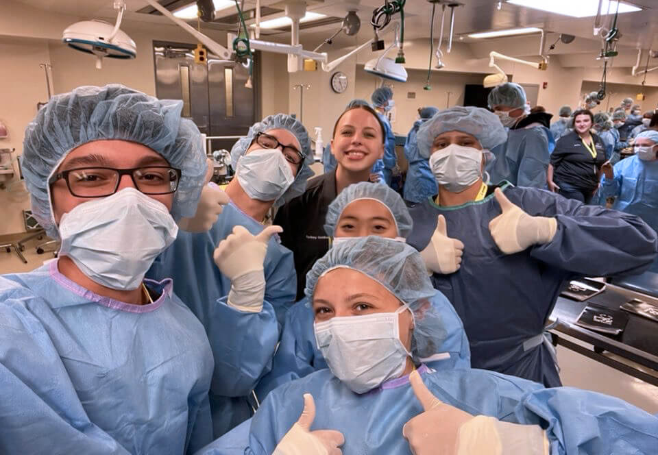 Campers wearing surgical gear give a thumbs up for the camera