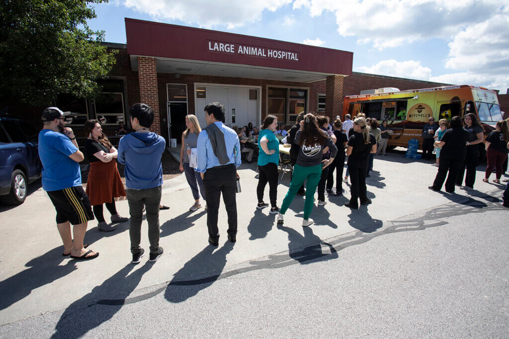 Faculty and staff line up to get food from a food truck