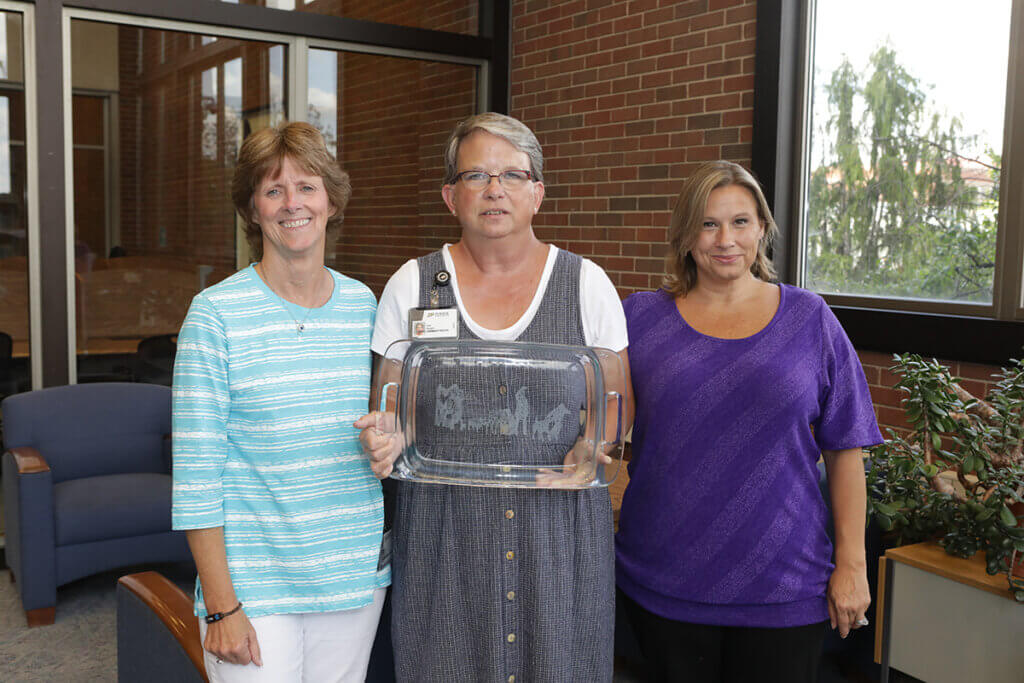 Account Clerk Lisa Wright with Business Manager Kathy Allen (left) and College of Veterinary Medicine Director of Financial Affairs Samantha McFarland, after receiving a glass baking dish engraved with the Continuum sculpture on the occasion of her retirement.