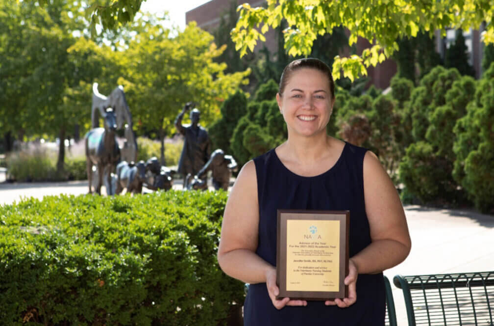 Senior Instructional Specialist and Veterinary Nursing Student Life and Activities Coordinator Jennifer Smith with the plaque recognizing her as recipient of the SCNAVTA Advisor of the Year Award.