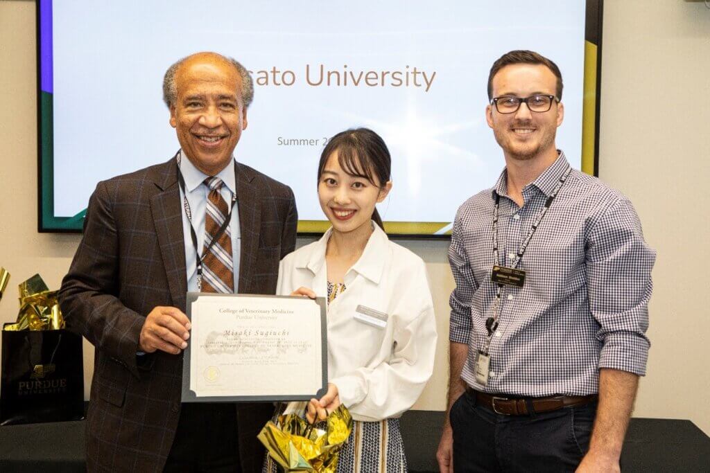 Kitasato student Misaki Sugiuchi, who spoke on behalf of the Kitasato delegation at the farewell reception, receives her certificate from Dean Willie Reed and Global Engagement Director Addison Sheldon.