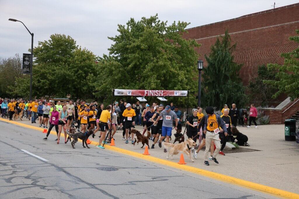 Runners and dogs charge off at the start of the 2022 Dr. Skip Jackson Dog Jog in front of Lynn Hall Saturday, September 24.