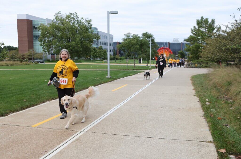 Dr. Sue Wardrip (PU DVM ’78), a regular participant in the annual Dr. Skip Jackson Dog Jog, traverses the course through Discovery Park with her canine companion.