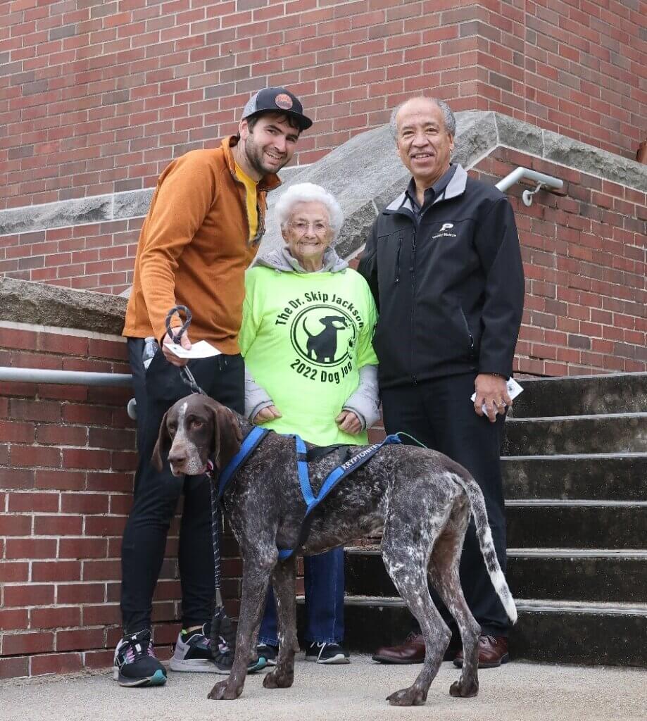 Chris Speers, with his dog DJ Kryptonite, is congratulated by Betty Jackson and Dean Willie Reed after winning the prize for fastest human canine pair.