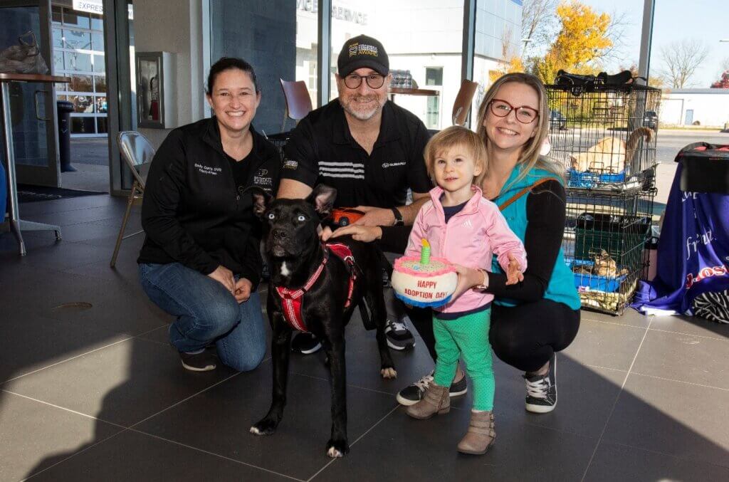 Dr. Emily Curry of the Priority 4 Paws program joins in a photo with Subaru staff member Robert Branch and his family after they adopted a dog named Rylee from the Almost Home Humane Society.