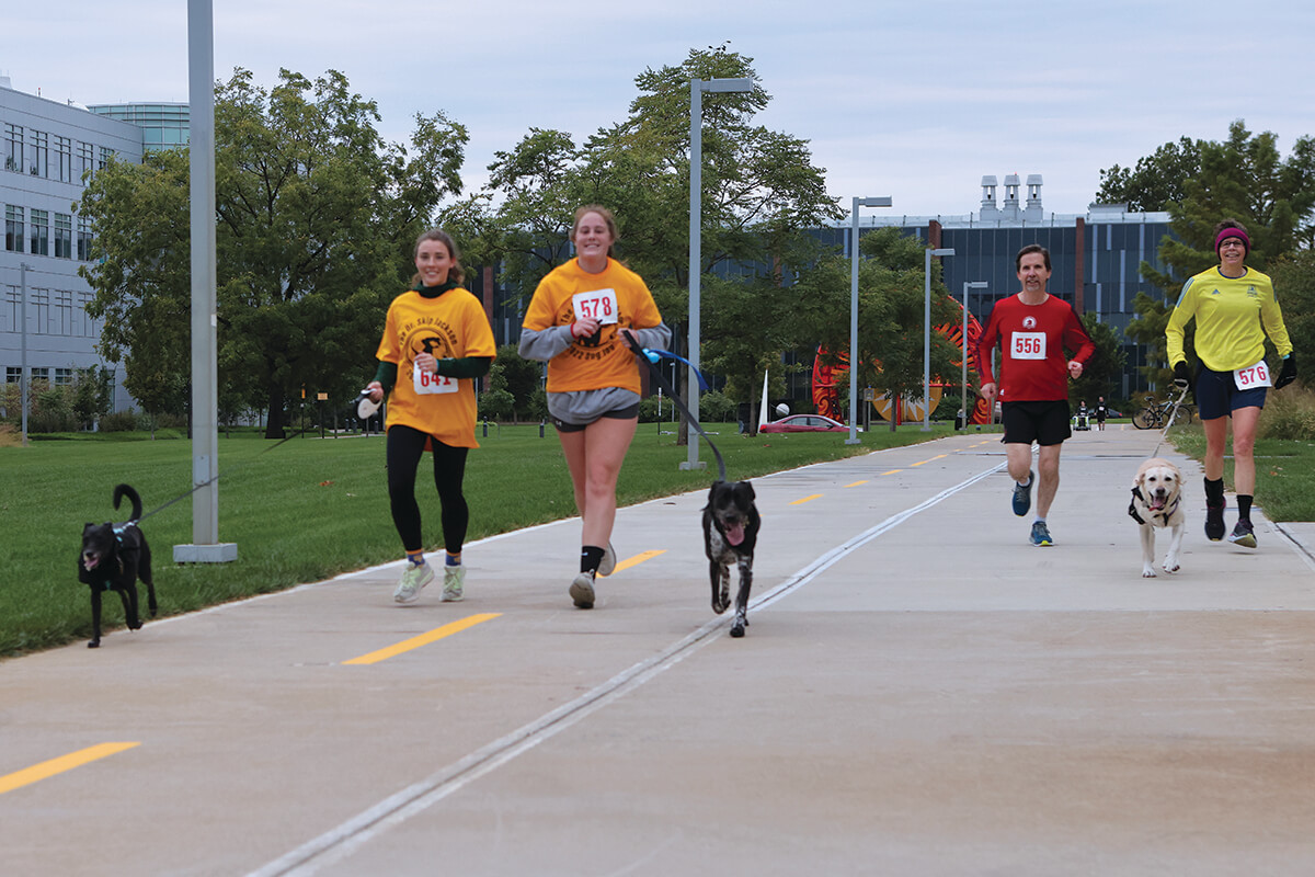 Runners along with some canine companions run the course during the 5k on Purdue's campus