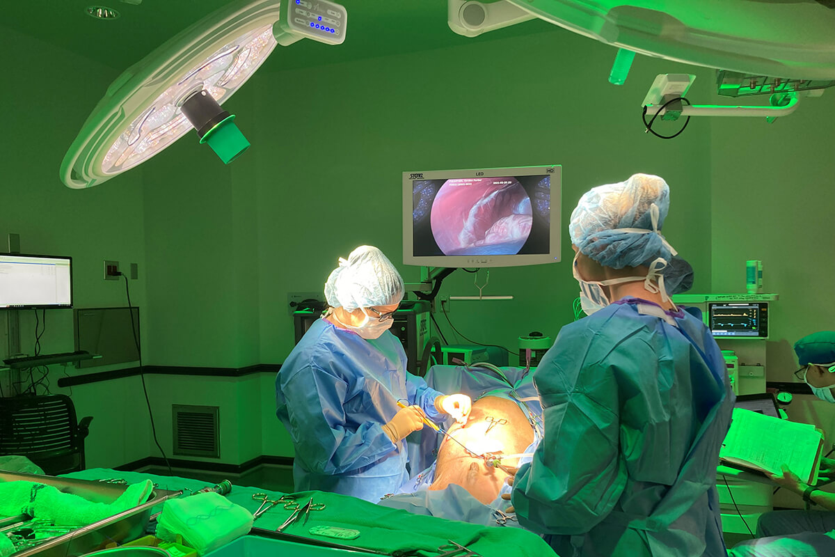 A surgery room is painted in bright green light as an operation is underway