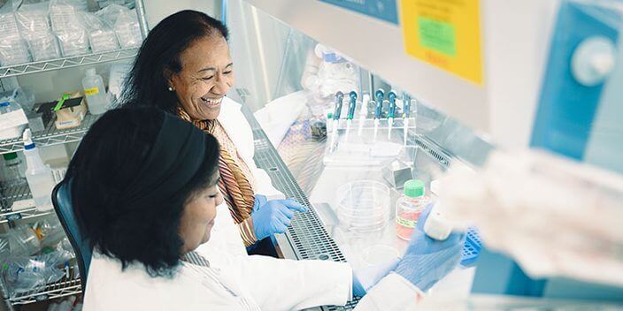 Dr. Mohammed smiles as she works beside a graduate student in her lab