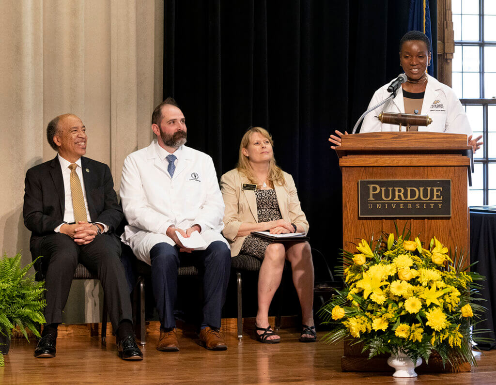 Zee speaks from the podium during the White Coat Ceremony