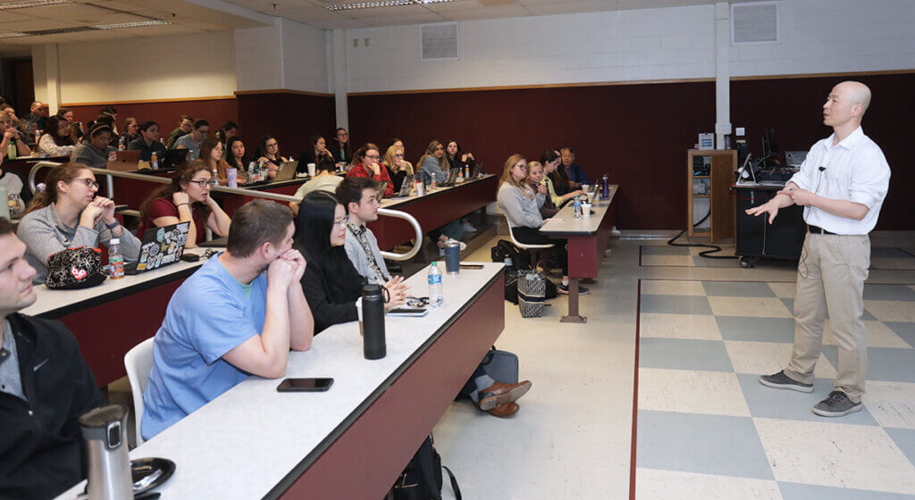 Dr. Kim speaks to a full classroom during Research Day