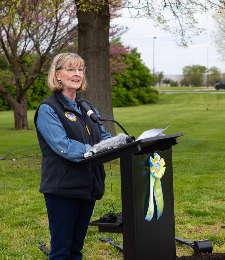 Sharon Dull speaks from the podium during the outdoor ceremony