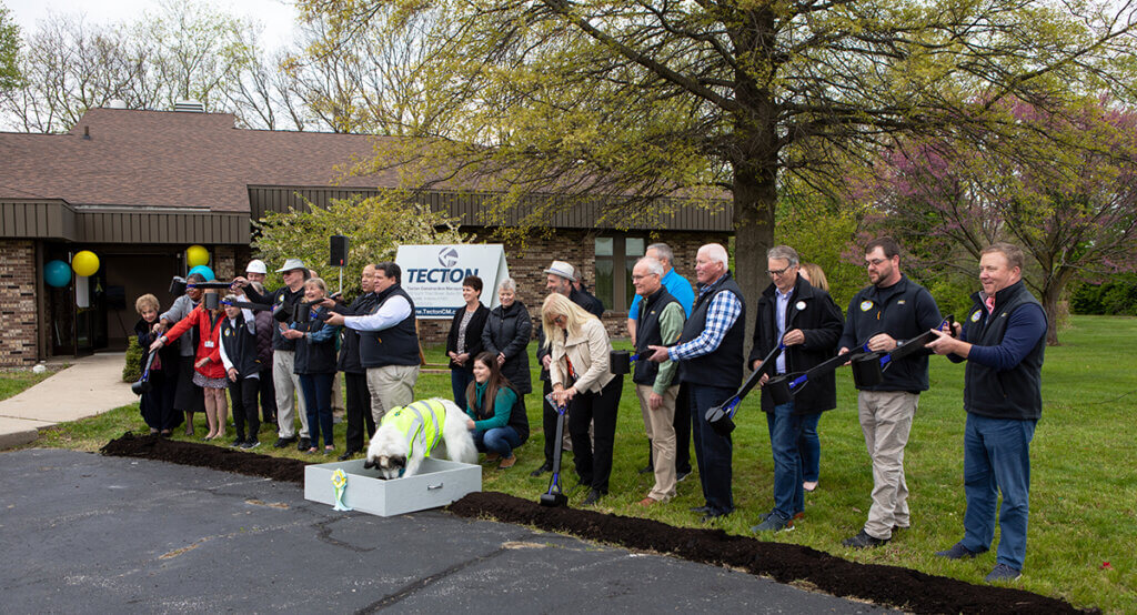 The group uses pooper scoopers to toss ceremonial dirt as Nora Bones digs to break ground on the new facility