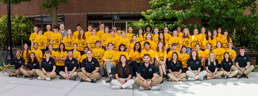 campers and camp counselors along with camp director Jim Weisman take a group photo outside of Lynn Hall