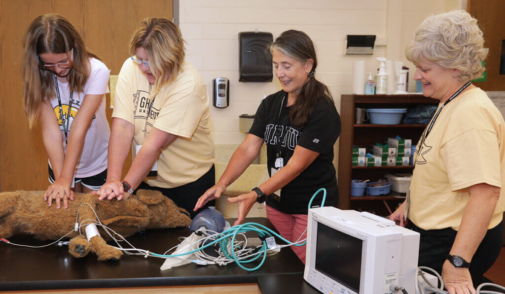 Veterinary Nurses instruct participants how to do CPR on a canine model