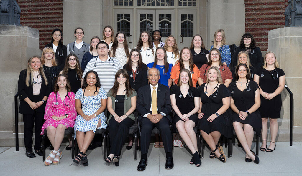 Classmates line up on the steps of the Purdue Memorial Union for a group photo joined by Dean Reed, seated in the center of the front row.