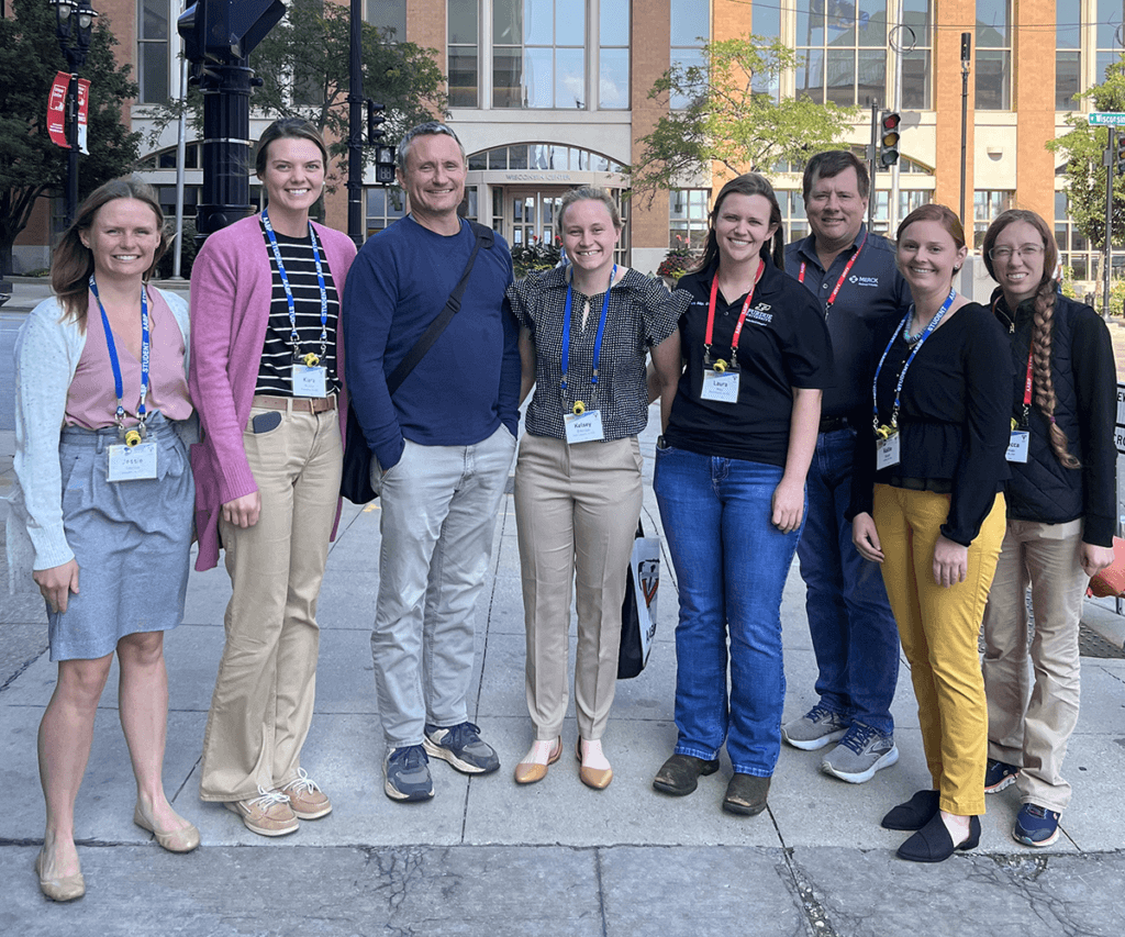 The group pause for a photo as they stand outside on a sidewalk outside of the AABP Conference hosted in Milwaukee, Wisconsin