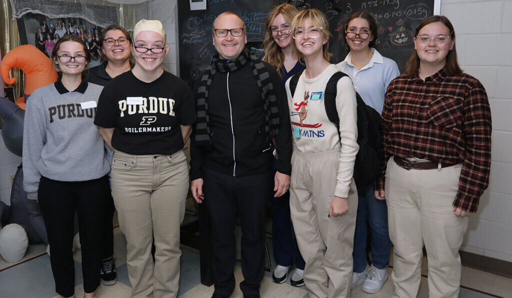 Students dressed as Dr. Brown for Halloween pose for a picture with him.