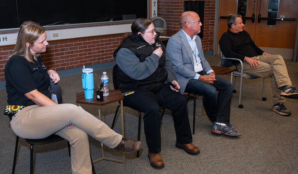 The panel members sit together looking toward the audience off camera