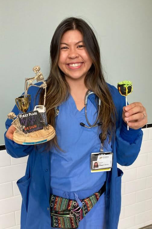 Bri holds up her award and a cake pop