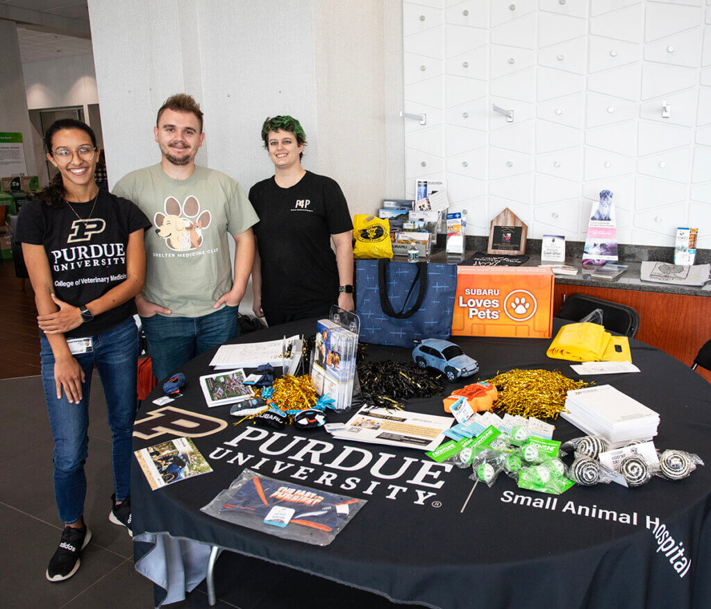 PVM reps stand beside a table of giveaways at the event in the Subaru showroom