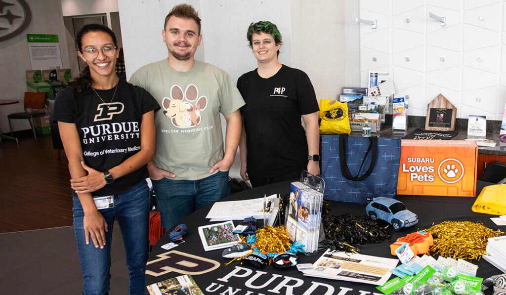 PVM reps stand behind a table of giveaways at the event in the Subaru showroom