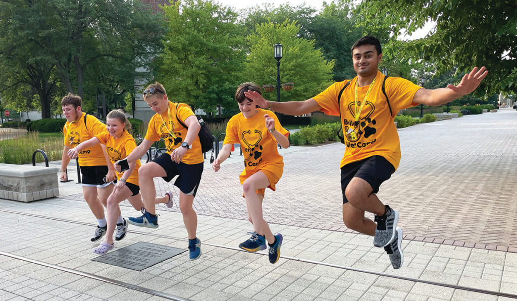 Campers jump over the ceremonial tracks on Purdue's campus