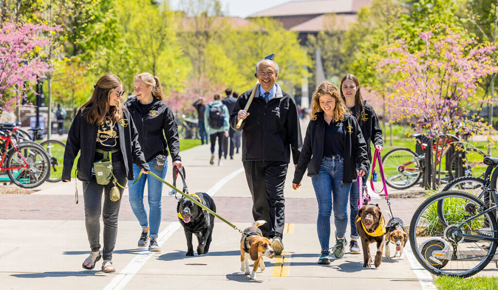 Dean Reed and some Canine Educators and their student handlers walk during the Purdue Day of Giving relay on campus
