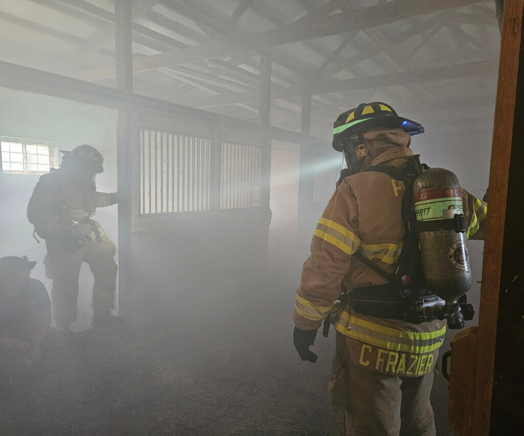 Training participants practice rescue techniques in a smoke filled barned during the training exercise