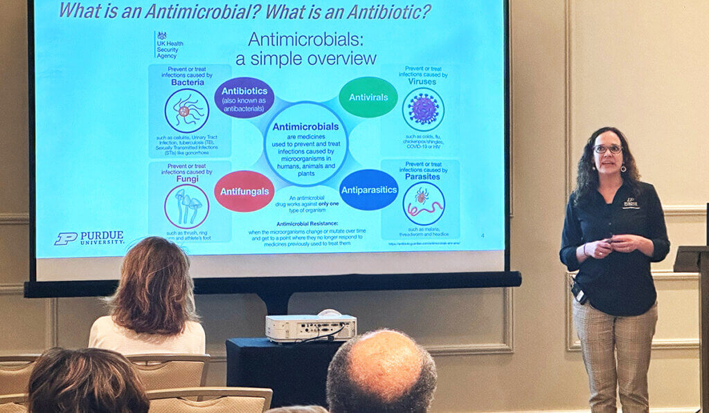 Dr. Hendrix leads a session on antimicrobial resistance standing next to a presentation screen.