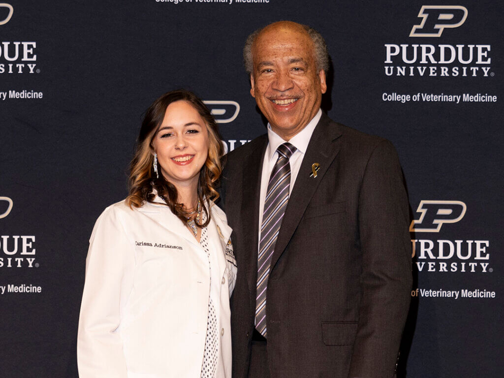 Carissa Adrianson pauses for a keepsake photo with Dean Reed after receiving her white coat. She also was presented with the Holly Watts Memorial Award.