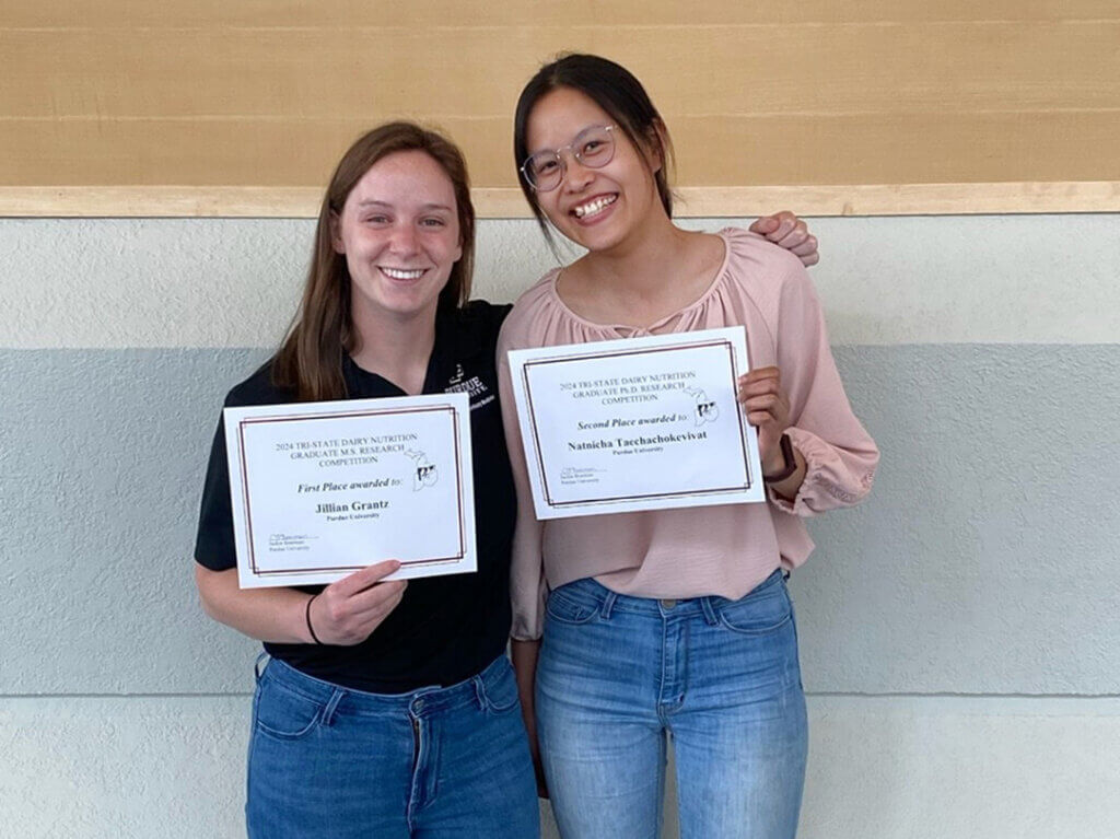 (left-right) VCS graduate students Jillian Grantz and Natnicha Taechachokevivat display the awards they won in the 2024 Tri-State Dairy Nutrition Conference Student Presentation Showcase.