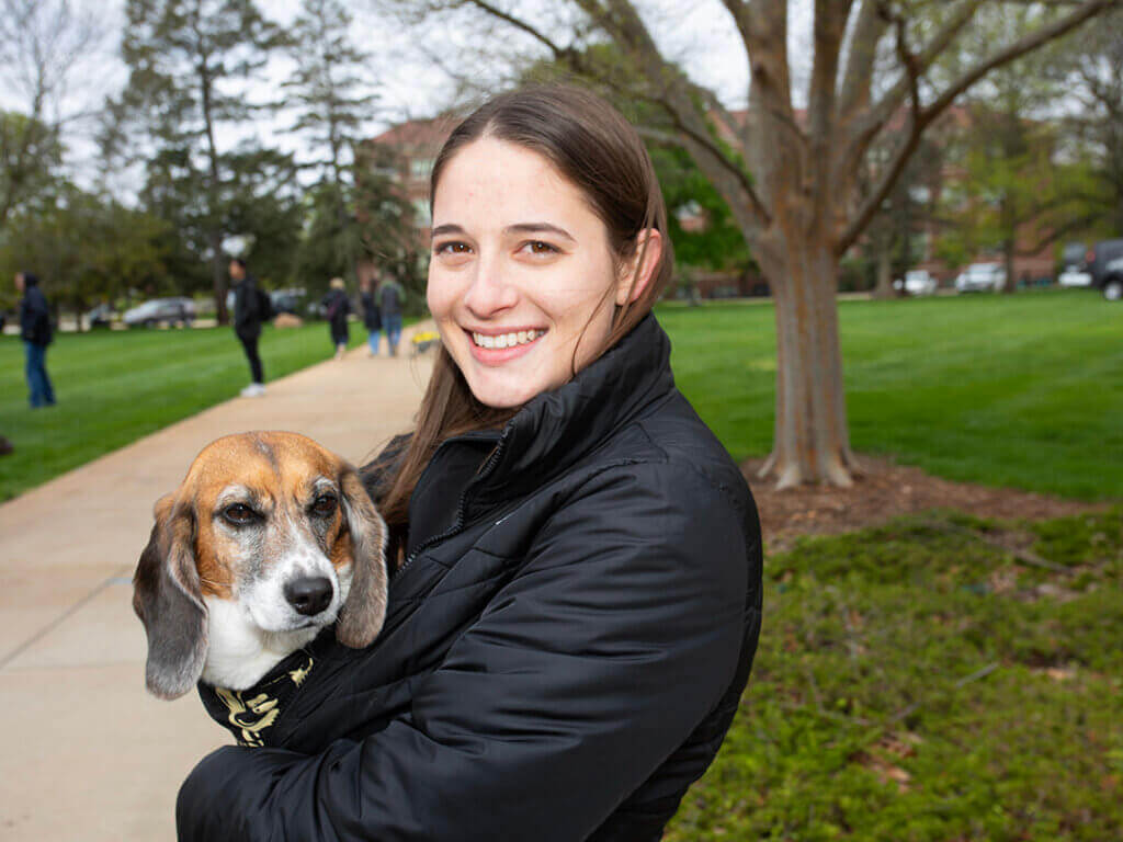 Canine Educator Bailey stayed close to his care team member, Allison Holahan of the DVM Class of 2025, during the brisk morning conditions on the Purdue Day of Giving.