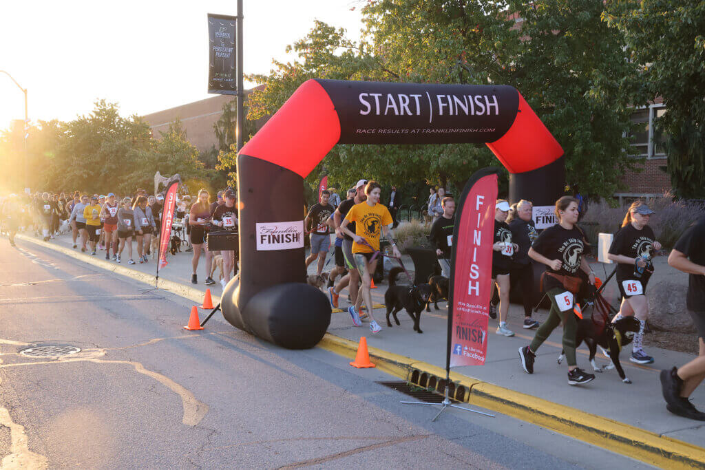 Runners and dogs charge off at the start of the 2023 Dr. Skip Jackson Dog Jog in front of Lynn Hall Saturday, September 24.