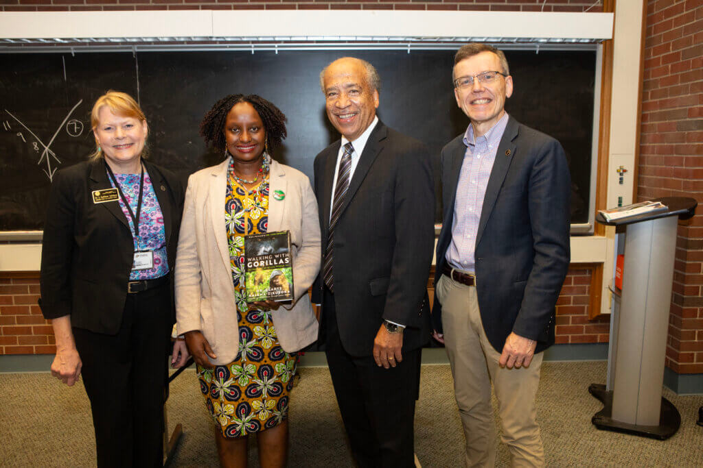 Dr. Gladys Kalema-Zikusoka, of Uganda, holding her book, Walking with Gorillas, is joined by (left-right) Interim Dean Kathy Salisbury, Dean Emeritus Willie Reed and Dr. Harm HogenEsch, Distinguished Professor of Immunopathology.