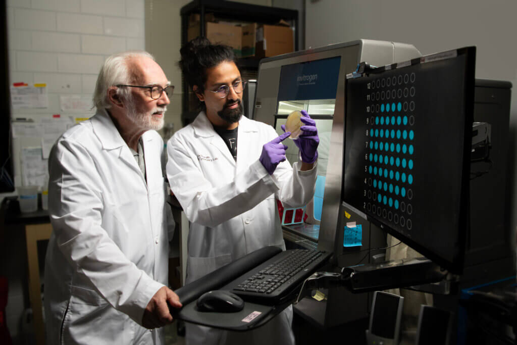 Postdoctoral researcher Sharath Iyengar, right, and J. Paul Robinson, Purdue Distinguished Professor of Cytometry, examine a sample plate in Robinson’s lab in Lynn Hall that uses a specially designed spectral cell sorter, technically known as a flow cytometer, for analyzing and identifying pathogens. (Purdue University photo/John Underwood)