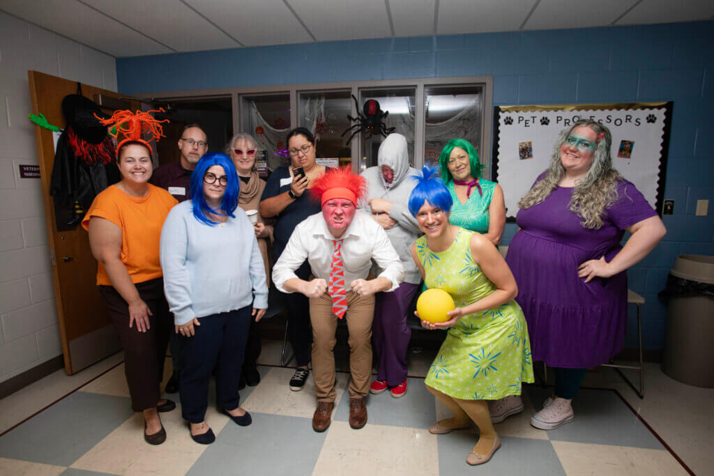 Characters who looked like they walked off the Inside Out 2 movie set gathered outside the Purdue Veterinary Nursing Programs Office in Lynn Hall (Front row, left-right): Anxiety (Jennifer Smith), Sadness (Holly Englert), Anger (Dr. Chad Brown), Joy (Beth Laffoon); (Back Row, left-right): “Apathy” (not actually an Inside Out character but it was the emotion “claimed” by Josh Clark), Nostalgia (Angella Arellano), Ennui (Chantalle Brown), Embarrassment (Holly McCalip), Disgust (Pam Phegley), and Envy (Taryn Adams).