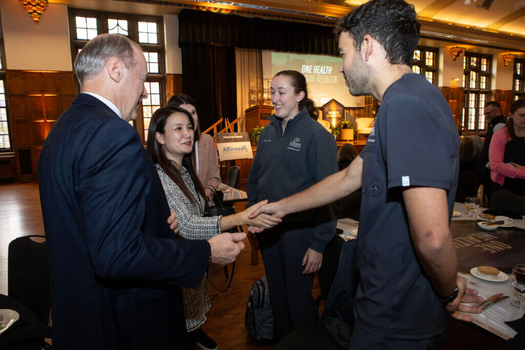 Dr. Kei Hui, Purdue’s First Lady, greets Purdue first-year veterinary student Nicholas Vedo, who is with classmate Jordan Kintigh and Dean Bret Marsh at the Purdue Memorial Union North Ballroom.