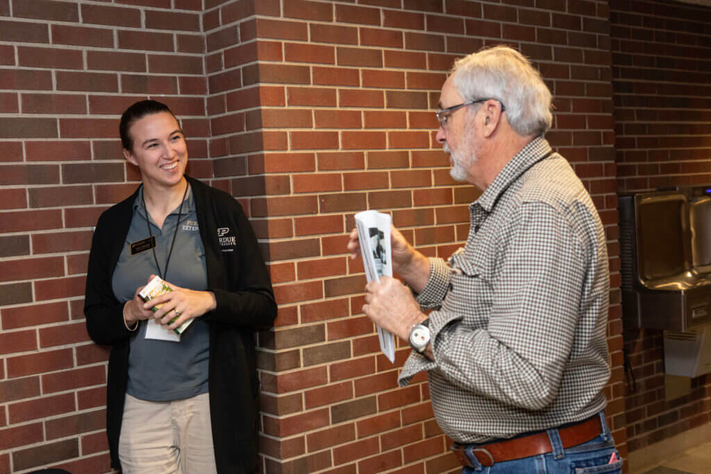 Purdue Extension Educator Cora Reinbolt talks with a workshop attendee before her presentation on Indiana Farm Extension Resources.