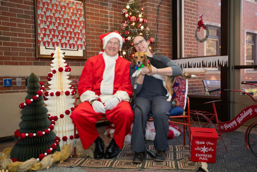 Canine Educators, some wearing fun holiday trim, stole the show, posing with Santa. The holiday setting for the photos, complete with festive décor, was created courtesy of the Canine Educator team, led by Sarah Schroeder, teaching animal protocol technologist.