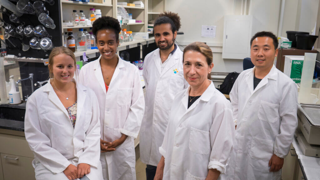 Dr. Andrisani standing in her lab with her lab members